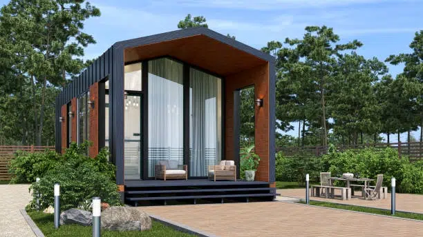 Modern ADU with tall windows, front porch, and outdoor seating. -adu floor plan